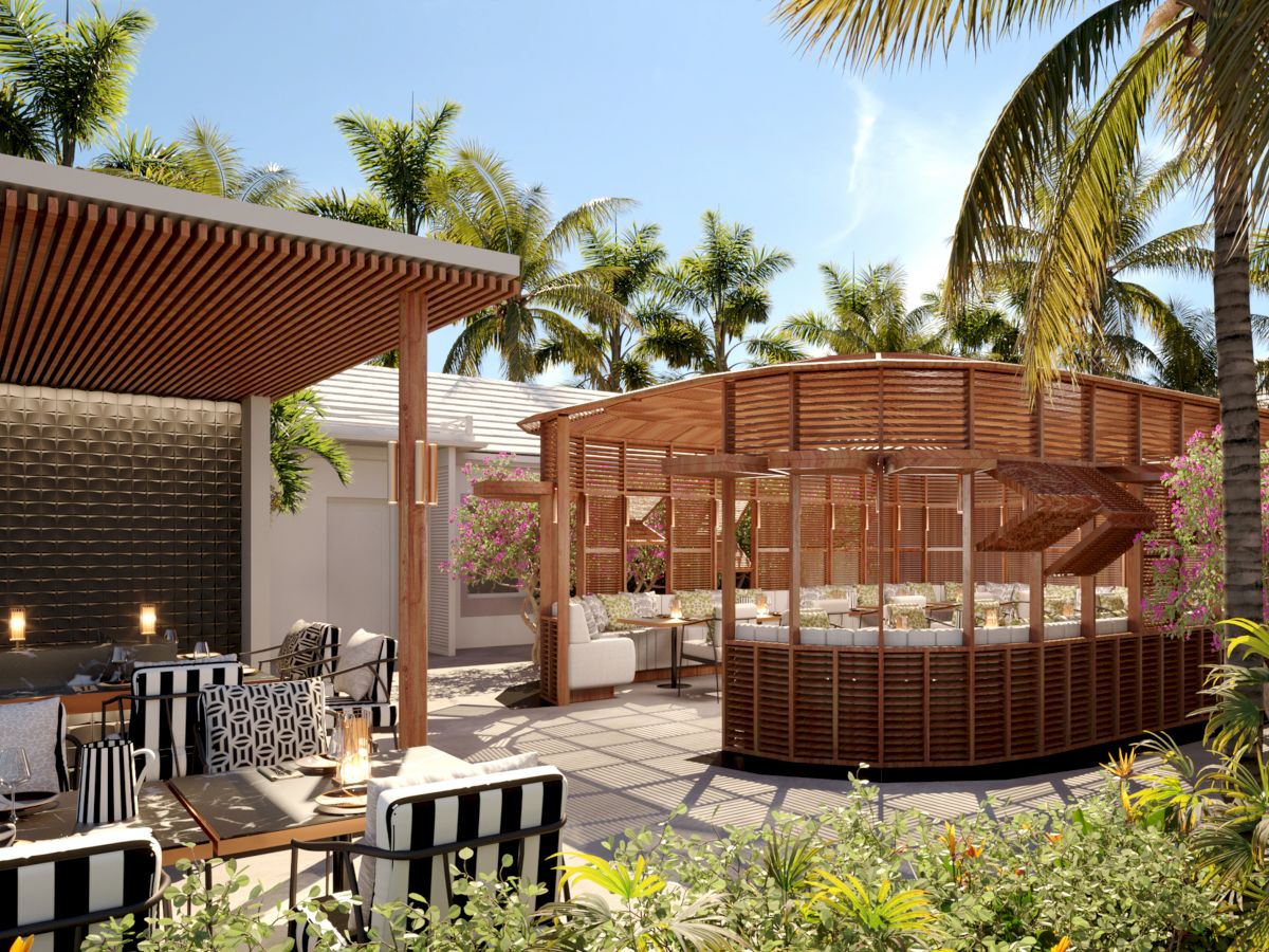 Outdoor seating area with wooden cabana and modern furniture, surrounded by palm trees and greenery under a clear blue sky.